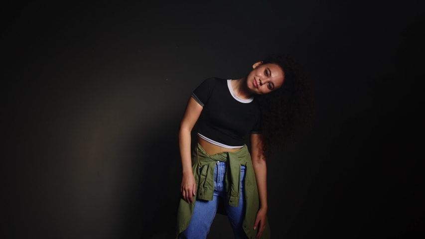 African-American woman dancing against dark background