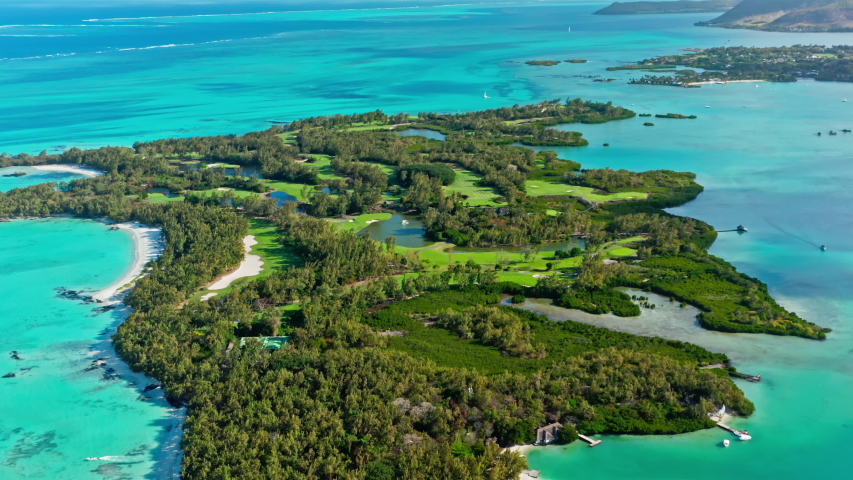 4K Aerial Drone Shot Flying Away Golf Course at Ile Aux Cerfs Small Tropical Island at the Mauritius with Cristal Clear Turquoise Water.