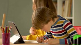 Cute little children use laptop for education, online study, home studying, Boy and Girl have homework at distance learning. Lifestyle concept for Family quarantine covid-19.