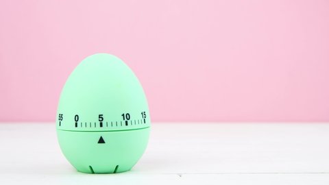 4K light green kitchen egg timer on a pink background. cooking time, soon Easter