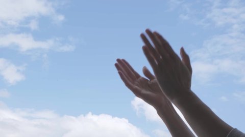 Applause. Woman hands applauding over blue sky background. Low angle view