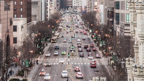 Chicago, United States - Mar 18, 2019: Time-lapse of car traffic transportation on road and people walk on Magnificent Mile shopping street district. Commuter transport or American lifestyle concept