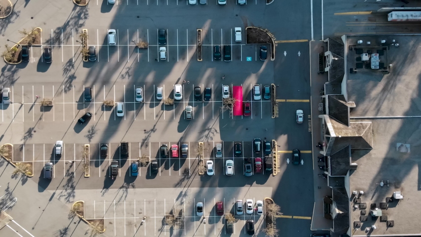 Drone aerial footage top down timelapse view of a large supermarket parking lot with cars parking and leaving. Royalty-Free Stock Footage #1050527842