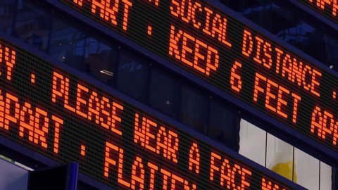 Closeup view of a Times Square ticker reminding pedestrians to keep 6 feet apart from each other. Social distancing was a common practice to slow the spread of COVID-19 during the pandemic of 2020.  	
