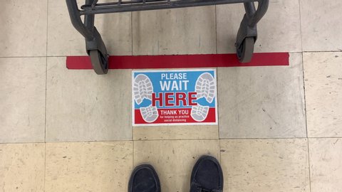 A view of a social distance sticker on the floor at the checkout line in a department store. Social distancing was a common practice to reduce the spread of COVID-19 during the pandemic of 2020.
