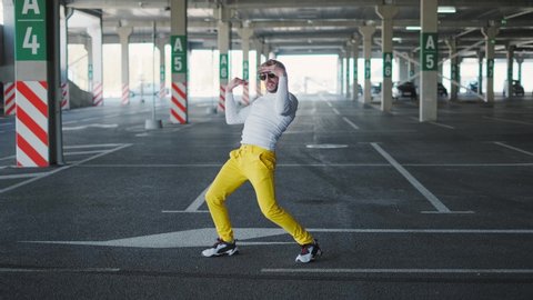 Contemporary street dancer man funky urban is dancing freestyle in the city. 4k slow motion. Businessman with glasses. Classical dance or ballet
