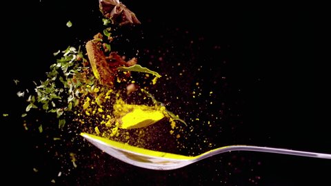 A Full Spoon exotic spice explode  on black background closeup in super slow motion