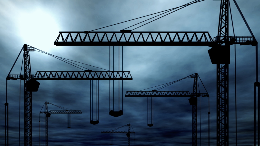 The silhouette of multiple tower cranes in front of a dramatic dark blue sky.