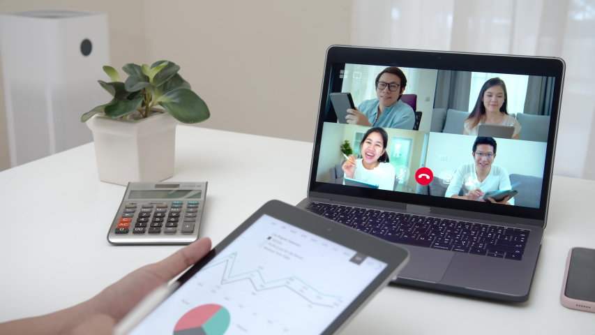 Zoom out of business woman talking about sale report in video conference. Asian team using laptop and tablet online meeting in video call.Working from home, Working remotely and Self isolation. | Shutterstock HD Video #1050600415
