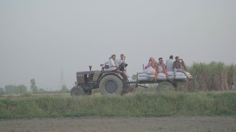 Meerut, Uttar Pradesh / India - 04 12 2019 People loaded on a tractor trolley with sacks of grain and fertilizer