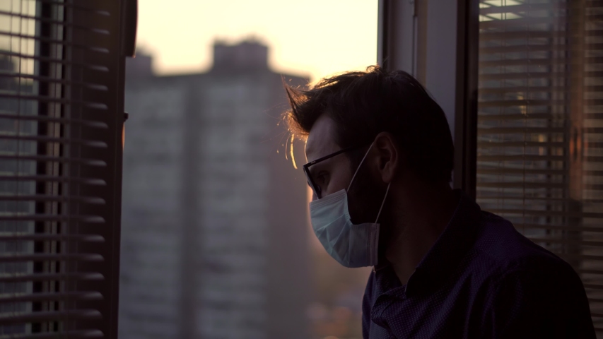 Man In Mask Looking In Quarantine Self Isolation. Stay At Home Self Isolation Coronavirus Covid-19 Pandemic Quarantine Protection.Man In Medical Mask Looking Through Window. | Shutterstock HD Video #1050611512