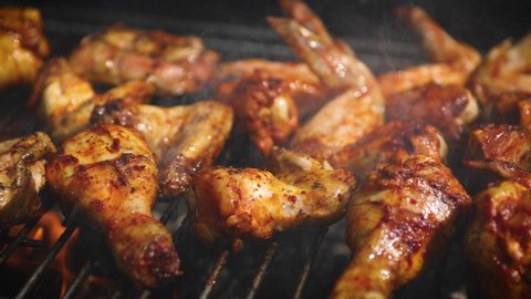 Delicious chicken pieces frying on barbecue grill. Outdoor summer party ideas.