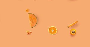 Creative video animation made of carrot, papaya, orange, grapefruit, apricot, melon, tangerine , curcuma, and pepper on the orange background. Flat lay. Food concept. Macro  concept.