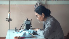 old Asian lady doing work with sewing machine . She is sitting and focus on the piece of fabric in her home - Powered by Shutterstock - Get 15% off with code: PIKWIZARD15