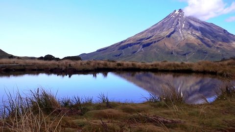 Rising camera showing a view of Mt. Taranaki from the right of the famous reflection pool.
