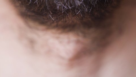 Macro footage of neck of young bearded man, selective focus
