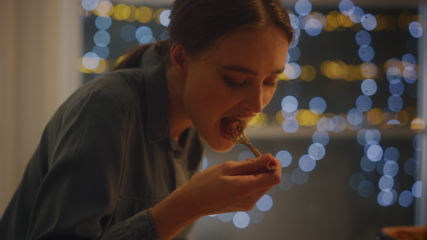 Portrait of a Beautiful Young Woman Eating Delicious Looking Pasta on the Plate. Profesionally Cooked Pasta Dish in the Restaurant or Romantic Dinner Meal at Home. Cozy Candle Light Royalty-Free Stock Footage #1050644746
