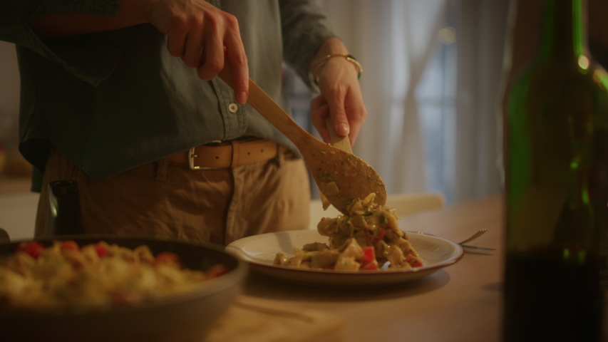 Person Serving Delicious Looking Pasta on the Plate. Serving Profesionally Cooked Pasta Dish in the Restaurant or for Romantic Dinner Meal at Home. Close-up Slow Motion Camera Shot