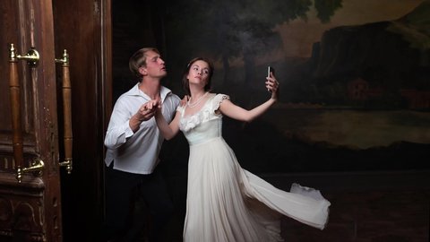 past and present together. kiss, young couple in love, portrait in style Renaissance. girl takes photo on smartphone, taking selfie. parallax effect