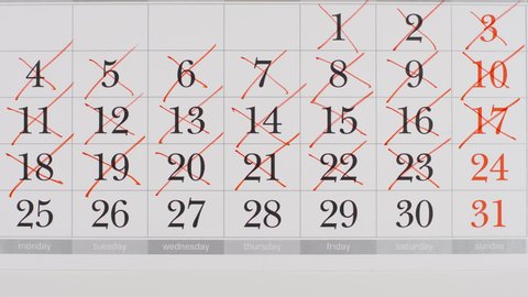 TOP VIEW: Crossing out a numbers in a paper calendar - Stop motion animation