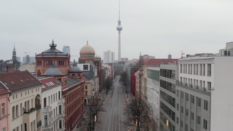 AERIAL: Slow flight trough Empty Central Berlin Neighbourhood Street with Cathedrals and view on Alexanderplatz TV Tower during Corona Virus COVID19 on Overcast Cloudy Day