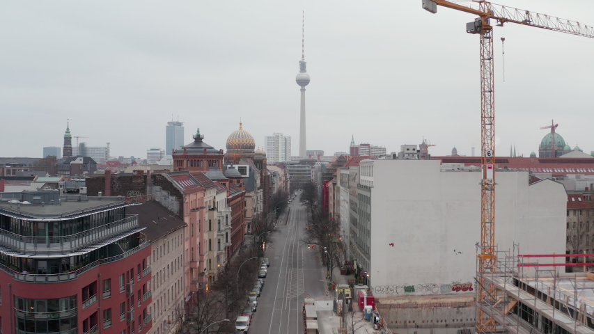 AERIAL: Slow flight trough Empty Central Berlin Neighbourhood Street with Cathedrals and view on Alexanderplatz TV Tower during Corona Virus COVID19 on Overcast Cloudy Day