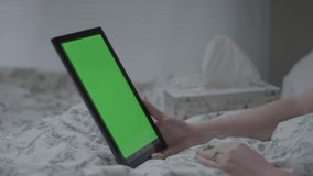 Closeup Sick Woman Using Tablet (With Green Screen) She Waves Hello, Uses Hand To Signal To Wait While She Blows Her Nose