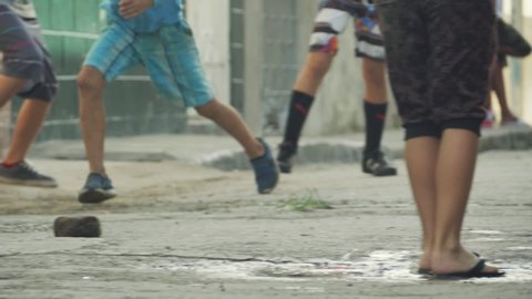 Poor children play football (soccer) outdoor. Football gane around the world concept. Young boys kids play soccer in ghetto, Cuba. Active lifestyle, authentic real video of people on Cuba