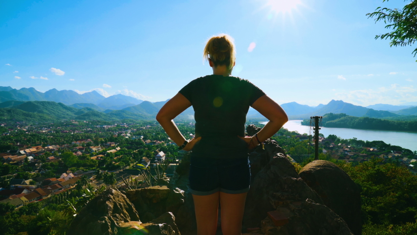 Rear View of Woman Tourist Looking at and Landscape and Skyline Cityscape View on Sunny Day in Luang Prabang, Laos