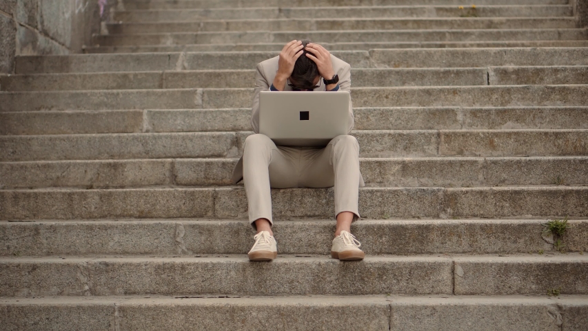Overwhelmed Exhausted Stressed Man. Tired Worker Overworked On Laptop. Frustrated Businessman Sitting On Steps.Remote Work Overtime.Workaholic Broker Internet Deadline.Tired Businessman In City Street | Shutterstock HD Video #1050677044