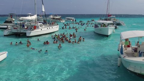Cayman Islands - 05/01/2019: People swim in the sea with turquoise water, where they sailed on yachts and small boats. This is an excursion during cruises in the Caribbean islands.