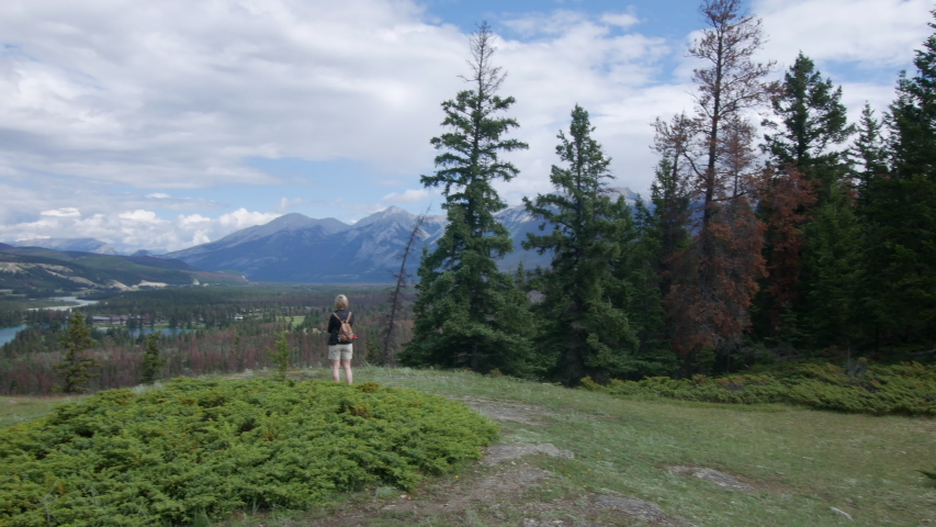 Panning shot of women looking at a sunning view of Athabasca river in Jasper National Park