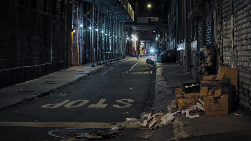 Urban New York City scenery, Manhattan narrow street by night, slow motion of people passing  