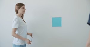 cheerful young couple choosing wall paint color for their new home decoration. 4k raw video footage slow motion