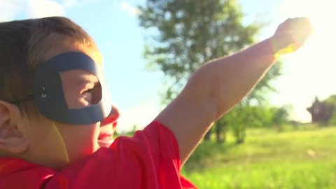 Superhero kid outdoors. Little Boy wearing Super hero costume Running In Summer Park. Full HD 1080p. High speed camera 240 fps Slow Motion
