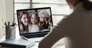 Young woman video calling big family in conference group chat. Long distance relatives enjoy virtual remote meeting during corona virus quarantine concept. Over shoulder closeup laptop screen view