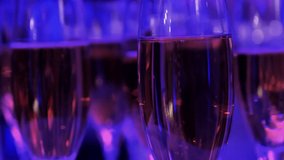 Glasses with champagne in neon blue light. The atmosphere of a night club. Blue and purple neon. Wellcome Drink at the party. - Powered by Shutterstock - Get 15% off with code: PIKWIZARD15