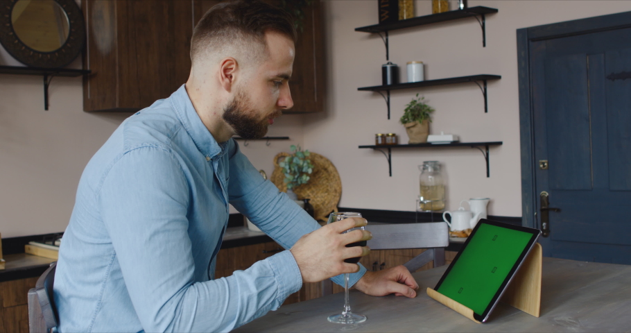 GREEN SCREEN CHROMA KEY Cucasian Hispanic man having a glass of wine during video call. Stay home, quarantine life