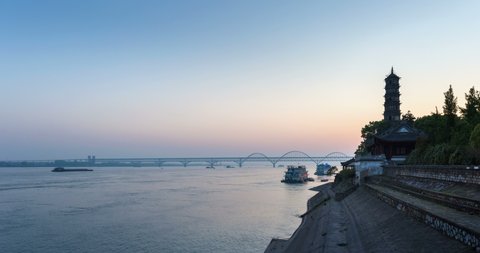 time lapse of the yangtze river landscape, jiujiang combined highway and railway bridge and ancient brick tower in sunrise, jiangxi province, China