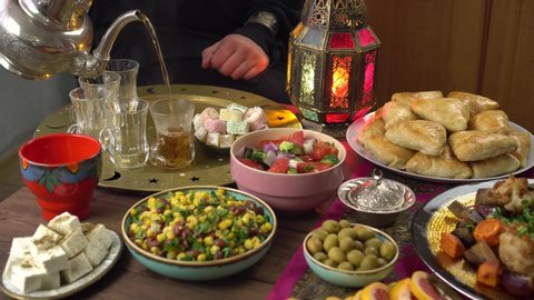 The Islamic holiday of Eid ul-Fitr marks the end of the Islamic fasting of the month of Ramadan. Traditional Eastern food and meal on the table. Muslim family eats together at home