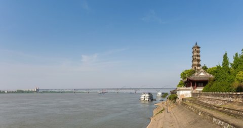 time lapse of the yangtze river landscape against a sunny sky, ancient brick tower and jiujiang combined bridge, jiangxi province, China