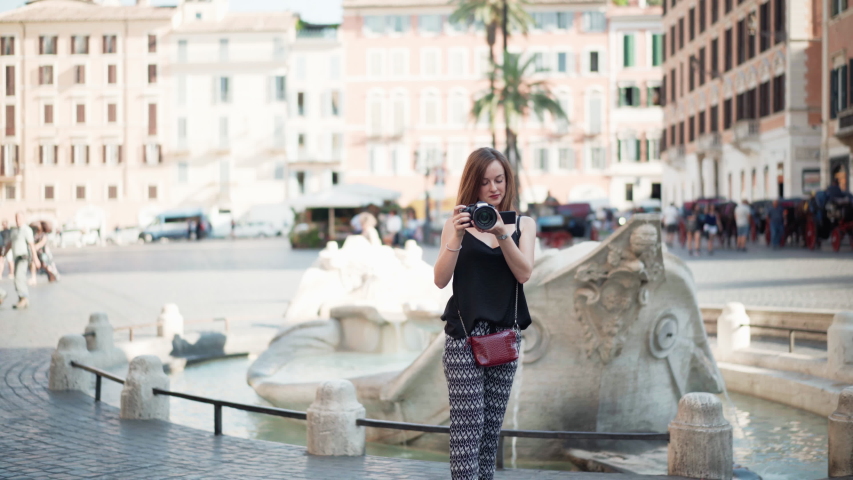Young creative camera operator recording people movements on the street. Attractive photographer taking pictures of city lifestyle, girl using black digital camera, hobby of photographer beginner