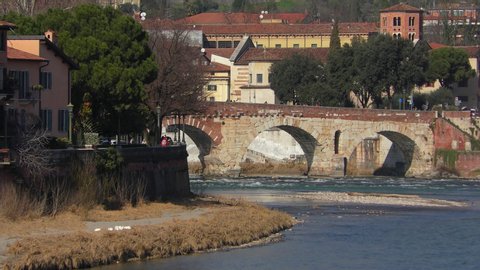Verona, Italy. Adige River and Stone Bridge (Italian: Ponte Pietro). Sunny winter day. Zoom out.