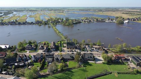 Aerial drone footage of the small dutch village Noordse Dorp on a sunny clear day. traditional old dutch village located amidst a water rich surrounding, frequently flooded.