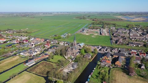 Aerial drone footage of the small dutch village Noorden on a sunny clear day. traditional old dutch village located amidst a water rich surrounding, frequently flooded.