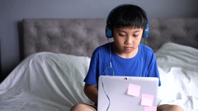 A boy wearing headphone for play game at home.  Learning and relax concept
