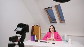 Female vlogger freelancer streams. The camera is close-up. View through the camera screen. The white room.
