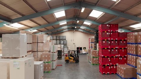 Leeds UK, 25th August 2019: Inside a warehouse showing rows of storage boxes on racks in a large storage warehouse with a fork lift truck driver driving around the warehouse taken with  a drone