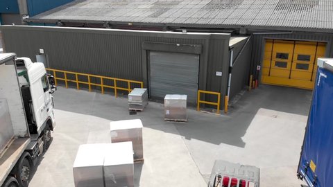 Leeds UK, 25th August 2019: Aerial footage of a fork lift tuck driver loading and unloading crates and pallets on to a truck in the storage warehouse outside yard