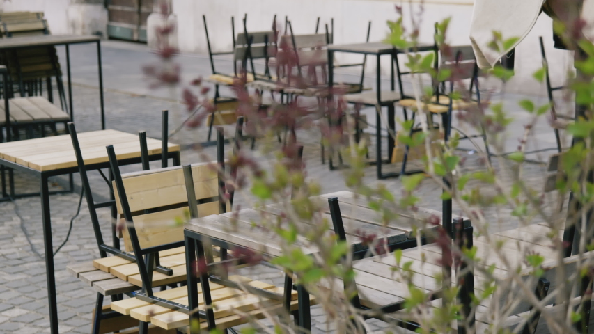 Close up shot of empty tables and chairs in the bar, restaurant, Ljubljana Royalty-Free Stock Footage #1050778642